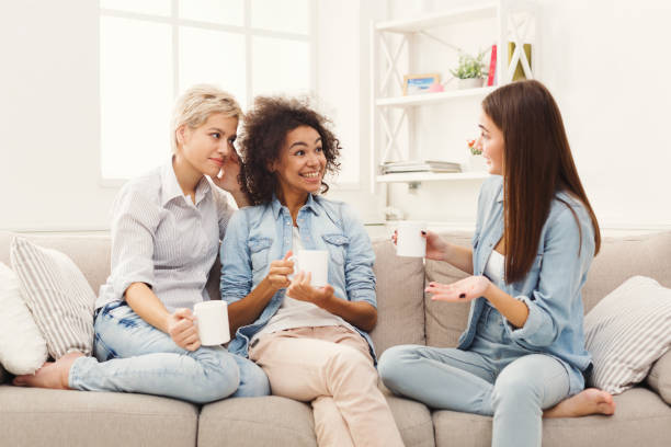 istock Three young female friends with coffee chatting at home 912018534