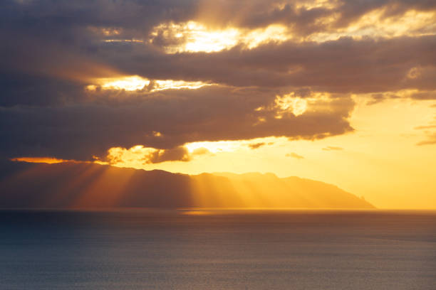 istock Sunset light behind clouds above mountains and ocean 912020516