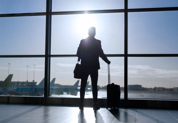 istock Businessman standing with suitcase in airport 912035880