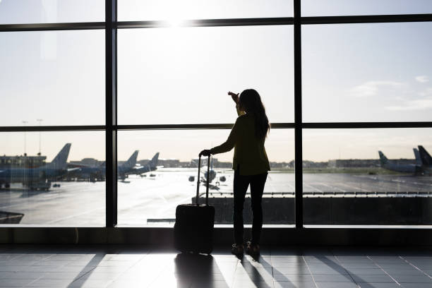 istock Woman with suitcase standing in airport 912036586