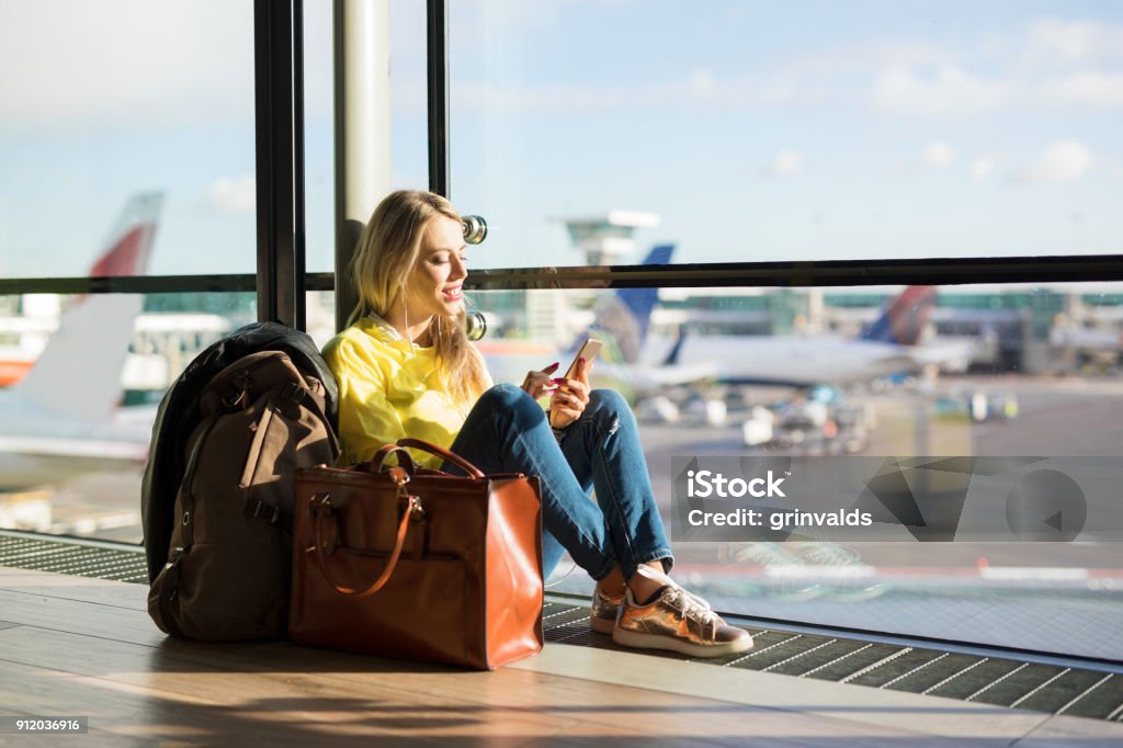 Mujer sentada en el aeropuerto y a la espera de su vuelo - Foto de stock de Aeropuerto libre de derechos