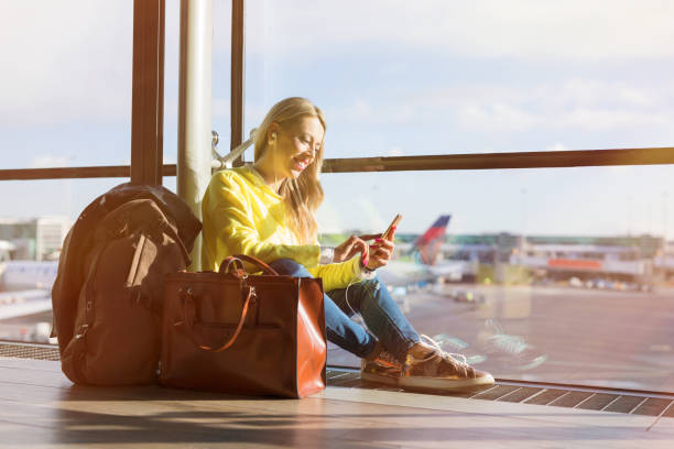 istock Woman sitting in airport and using her smartphone 912037064