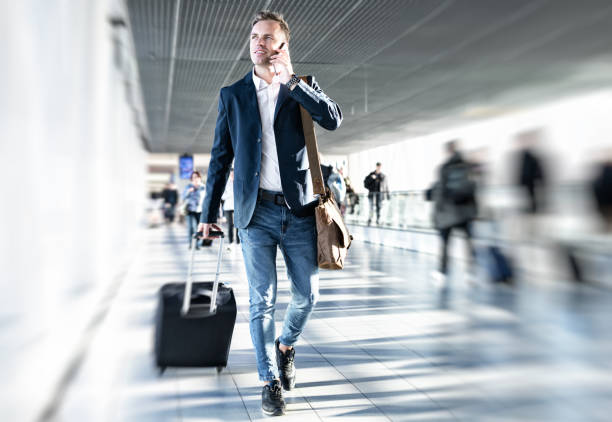 Businessman walking in airport Businessman talking on phone and rushing in airport, blurred background business travel stock pictures, royalty-free photos & images