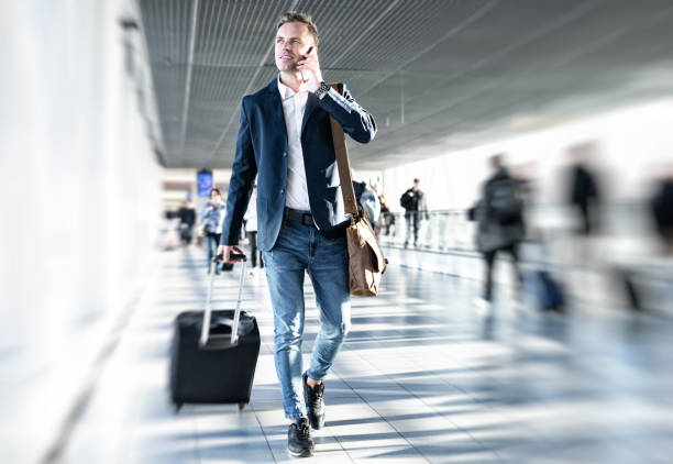 Businessman walking in airport Businessman talking on phone and rushing in airport, blurred background business journey stock pictures, royalty-free photos & images