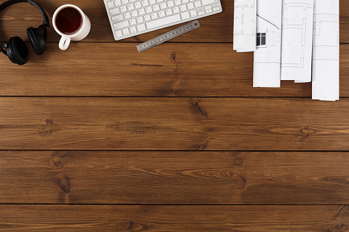 Workplace of architect. Engineering tools for creating new architectural project, coffee cup and keyboard on wooden table, top view, copy space