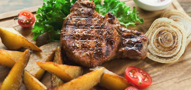 istock Grilled pork steak with potato wedges closeup 912043458