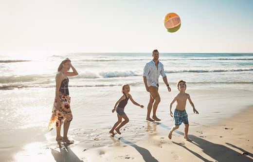 Shot of a family of four spending the day at the beach