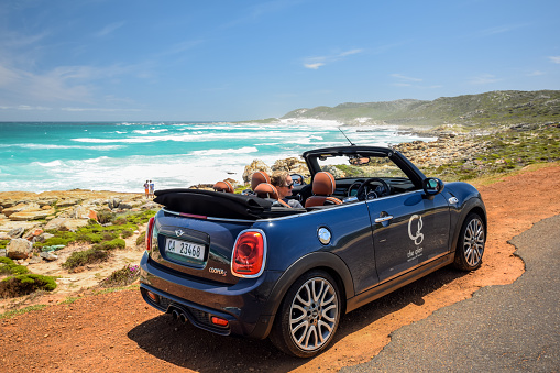 Cape Of Good Hope, South Africa - November 28, 2017: A MINI Cooper S Convertible rental car, owned by The Glen Boutique Hotel in Cape Town, parking at a beach with the roof down. MINI is owned by BMW.