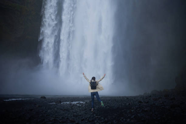 istock girl runs to the skogafoss waterfall 912052734