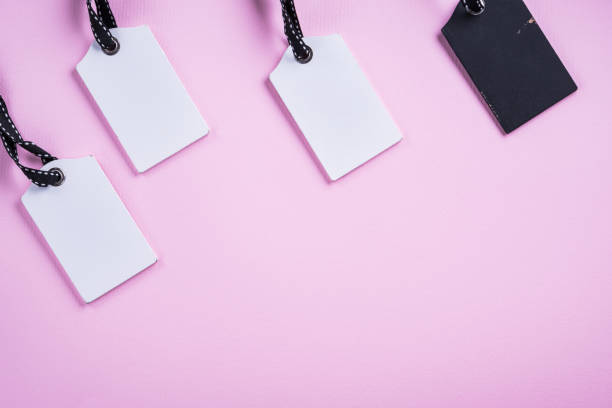 istock Empty white and  black tags in a row on pink background. Top view. Mock up sample. Blank price tag. Design for shopping label template, discount, Sale. Sales tags. 912053402