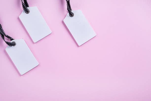 istock Empty white tags in a row on pink background. Top view. Mock up sample. Blank price tag. Design for shopping label template, discount, Sale. Sales tags. 912053414