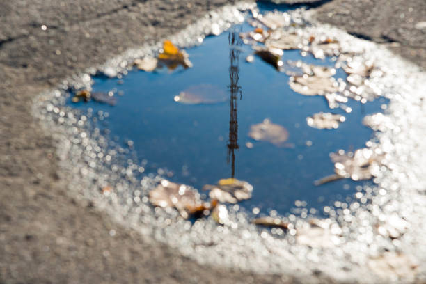 istock A puddle of water on the road surface (asphalt) 912057956