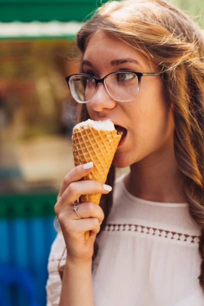 istock Young beautiful girl eating ice cream 912069606