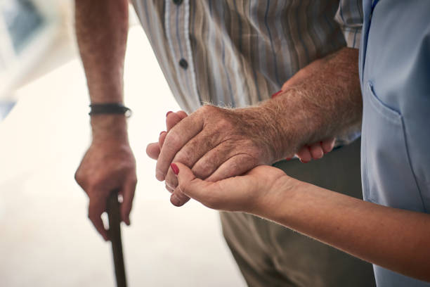 infirmière soutenant senior homme à marcher - human hand old senior adult holding hands photos et images de collection