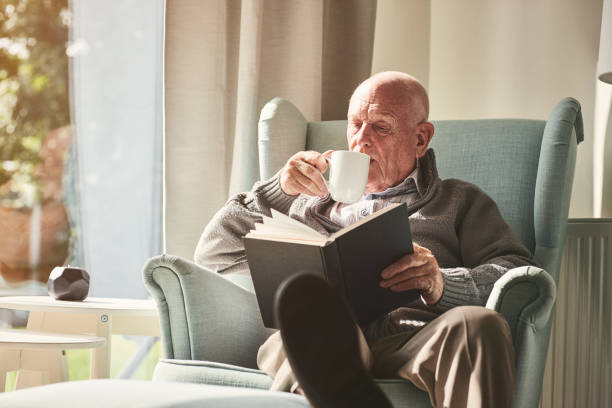 istock Senior man relaxing at home reading book 912073222