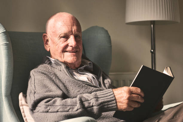 istock Happy senior man relaxing at home with a book 912073250