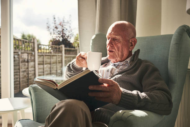istock Elderly man relaxing at home reading book 912073258