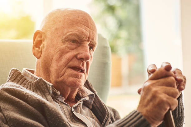 istock Pensive old man sitting at home 912073264