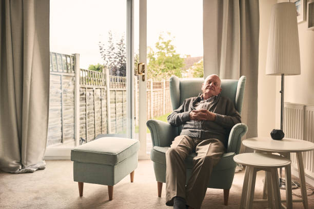 Senior man sleeping on a armchair Indoor shot of senior man sitting on a armchair and sleeping at home man sleeping chair stock pictures, royalty-free photos & images