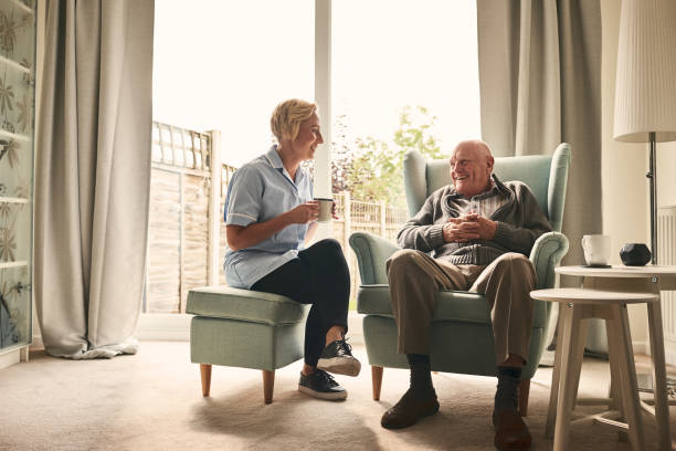 istock Relaxed elderly man and female nurse having coffee 912073310