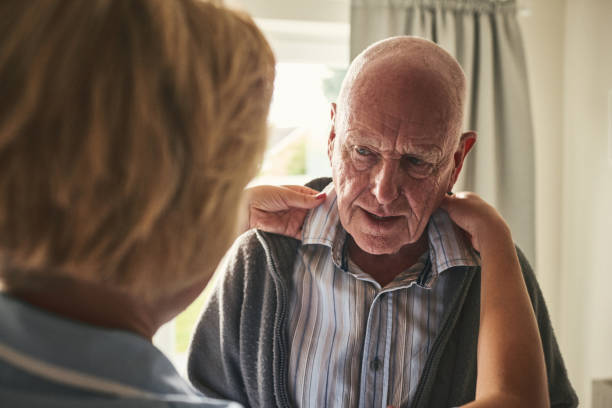 Caregiver helps dressing elderly patient at home