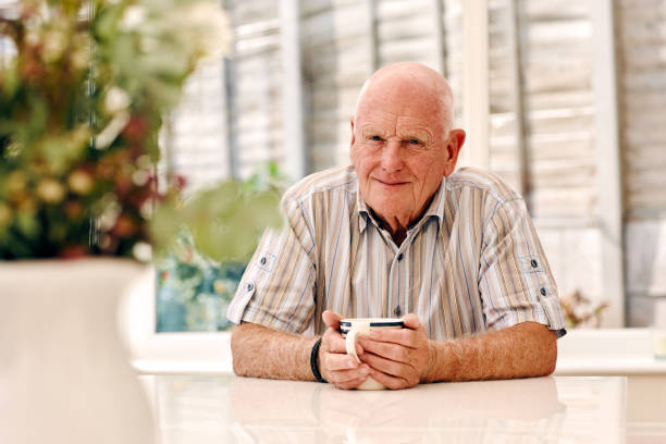 istock Senior man sitting at dinning table with a cup of coffee 912073406