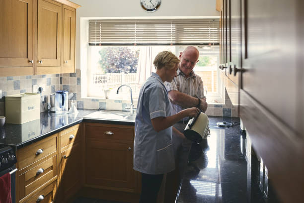 istock Female carer making coffee for senior man 912073456