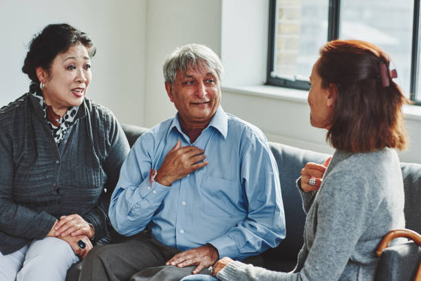 Female carer treating senior couple Female carer treating senior couple retirement home sign language stock pictures, royalty-free photos & images