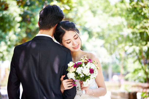 portrait of an asian wedding couple portrait of young asian bride and groom at wedding ceremony. chinese wedding dress stock pictures, royalty-free photos & images