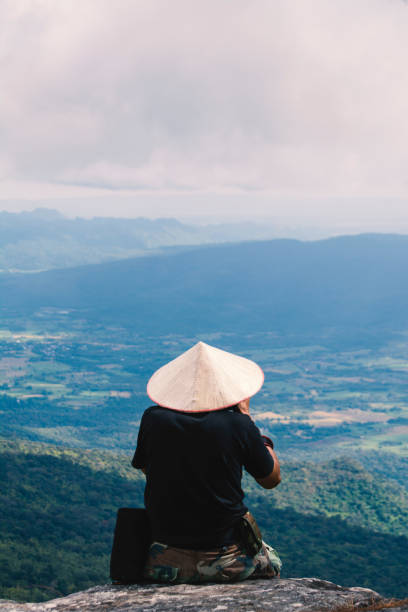 istock Rear View Of Man Sitting On Cliff Against Mountains 912080906