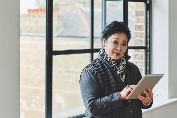 istock Elderly woman standing at home with a digital tablet 912082182