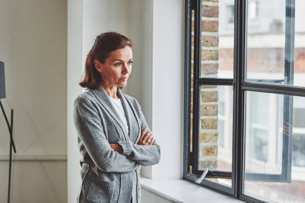 istock Pensive senior woman looking outside the window 912082186