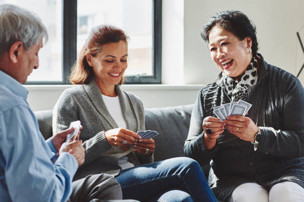 istock Senior people playing cards game at home 912082190