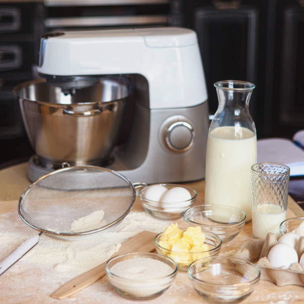 istock Baking ingredients on kitchen table. White products prepare for cooking on wooden cutting board. Lifestile food concept. 912084228