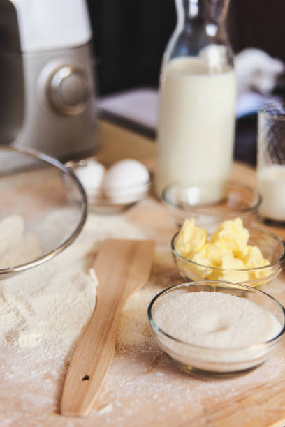 istock Baking ingredients on kitchen table. White products prepare for cooking on wooden cutting board. Lifestile food concept. 912084294