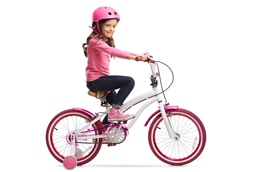 Little girl with a bicycle isolated on white background