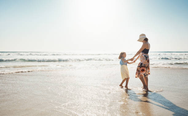 Oh what delightful days Shot of a mother and her little daughter bonding together at the beach delightful stock pictures, royalty-free photos & images