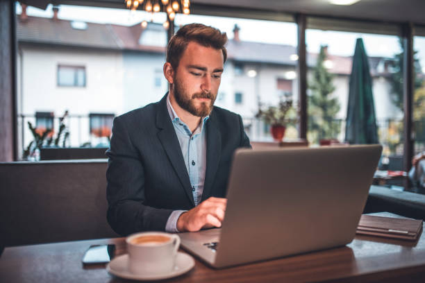 istock Businessman using laptop in a coffee shop 912112542