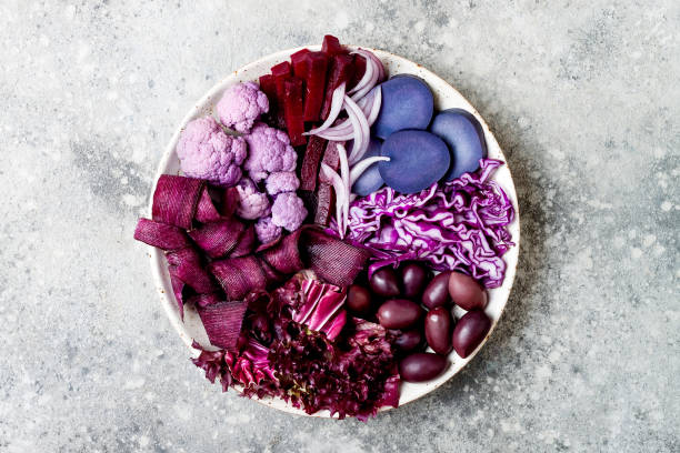 Purple Buddha bowl with spiral carrots, cauliflower, beet, onion, potato, shredded red cabbage, radicchio salad, kalamata olives. Vegan detox veggie bowl stock photo