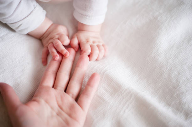 mani di un neonato tra le dita della madre - cute kid foto e immagini stock