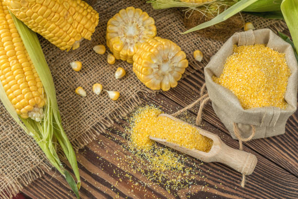 istock Fresh corn on cobs on rustic wooden table, top view. Dark wooden background freshly harvested organic corn. Corn grits in cloth sack. 912116346