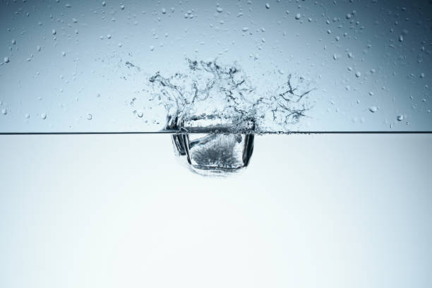 istock ice cube in water with splash, isolated on white 912116458