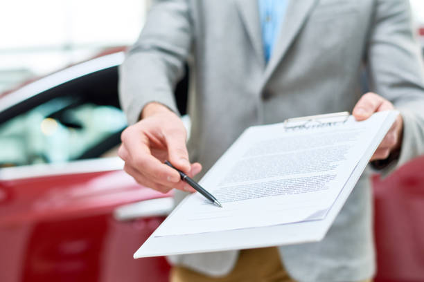 istock Close Up Car Salesman Handing Contract to Client 912116904