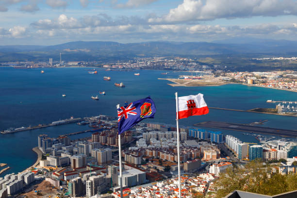 vue du rocher de gibraltar. drapeaux du royaume-uni et à gibraltar dans le vent. - rock of gibraltar photos et images de collection