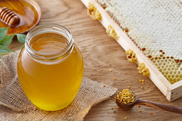 istock Honey jar, bee pollen and honeycombs on wooden table 912117626