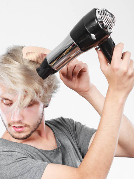 istock Young man drying hair with hairdryer 912120170