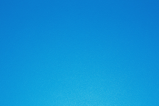 Blue plastic background with gradient paint and dotty texture. Horizontal close-up capture.