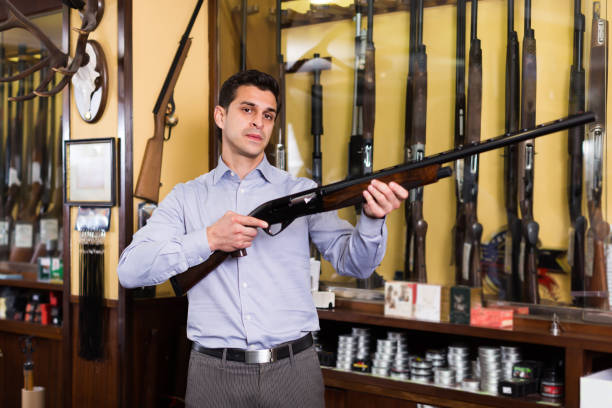 istock Cheerful male hunter choosing shotgun in store 912128644