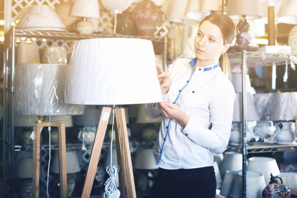 istock Happy woman is standing with modern lamps 912128930