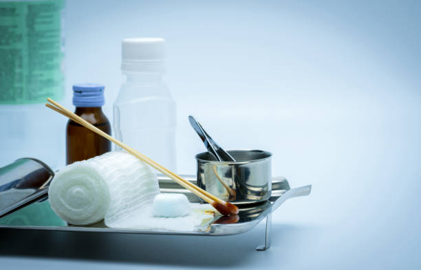 Wound care dressing set on stainless steel plate. Cotton ball with alcohol, cotton stick with povidone-iodine, forceps and conform bandage. Wound care dressing set on stainless steel plate. Cotton ball with alcohol, cotton stick with povidone-iodine, forceps and conform bandage. saline drip stock pictures, royalty-free photos & images